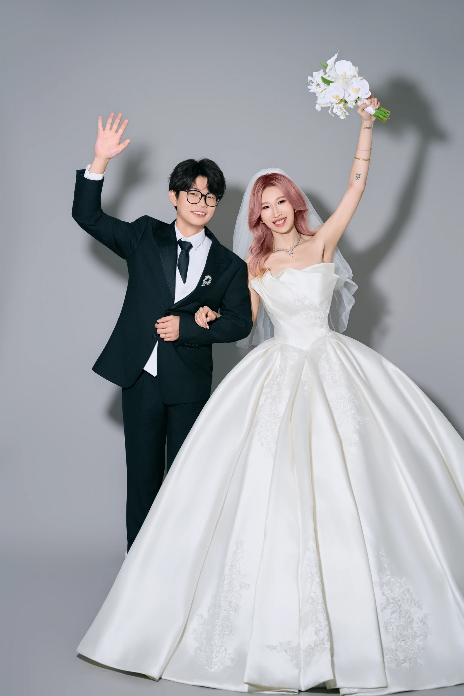 新郎挥手、新娘举起花束，与手绘插画动作相同的婚纱照